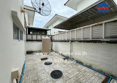 Small backyard with tiled floor and satellite dish