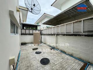 Small backyard with tiled floor and satellite dish