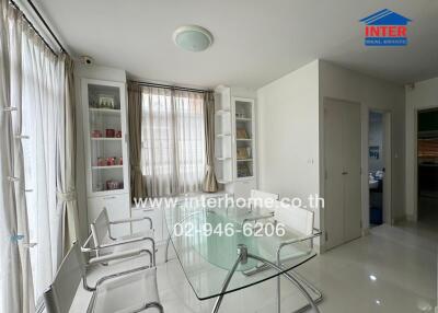 Bright dining area with glass table and white chairs