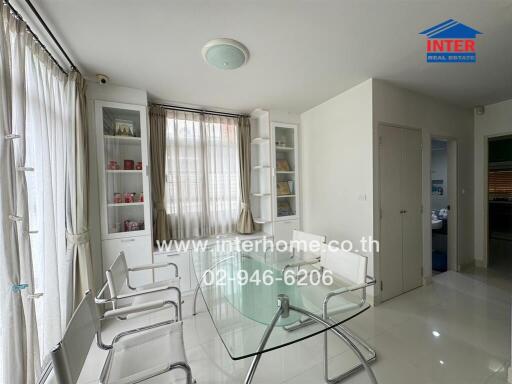 Bright dining area with glass table and white chairs