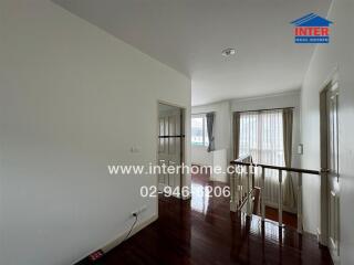 Bright hallway with wooden floor and large windows