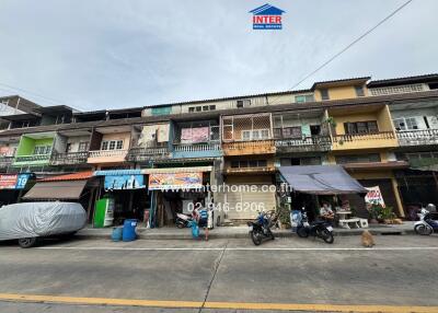 Front view of residential and commercial building with multiple floors and various businesses on the ground floor