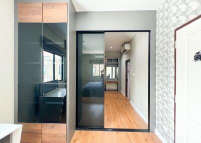 Modern bedroom with a large mirrored wardrobe and wood flooring