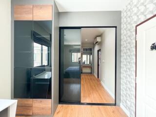 Modern bedroom with a large mirrored wardrobe and wood flooring