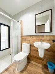 Modern bathroom with toilet, sink, and shower