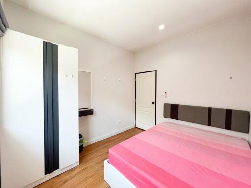 Modern bedroom with bed, wardrobe, and a dressing area
