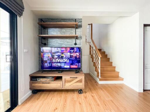 Modern living room with TV and staircase