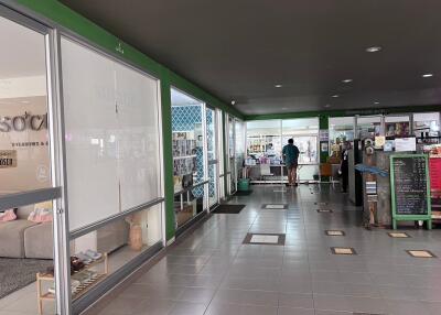 Interior view of a commercial building with shops and a man walking