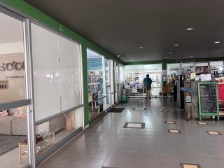 Interior view of a commercial building with shops and a man walking