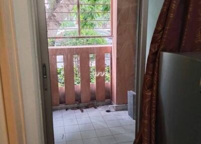 View of a balcony with a sliding door, railing, and tree outside