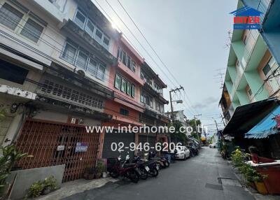 Exterior street view of residential buildings with parked motorcycles