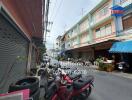 Street view with parked motorbikes in front of residential buildings