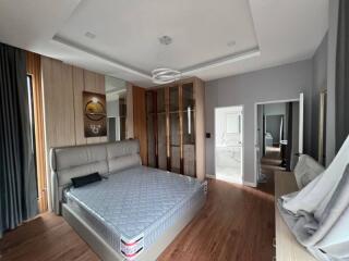 Modern bedroom with a large bed and wooden flooring
