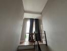 Indoors staircase with natural lighting and window curtains