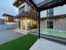 Modern two-story house with large windows, swimming pool, and outdoor seating area