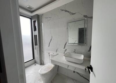 Modern bathroom with large window and marble tiles