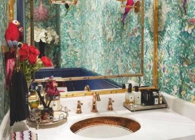Elegant bathroom with floral wallpaper, gold fixtures, and decorative elements