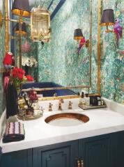 Elegant bathroom with floral wallpaper, gold fixtures, and decorative elements