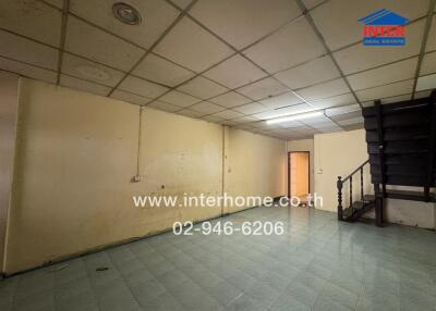 Spacious room with tile flooring and staircase