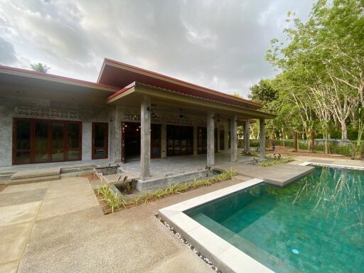 Outdoor view of a modern property with a swimming pool and covered patio