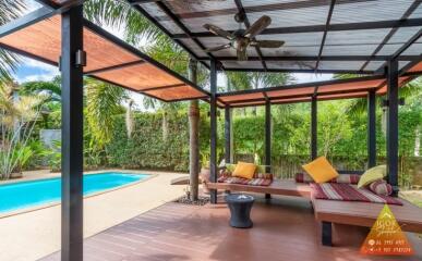 Covered patio with seating area next to a swimming pool