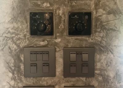Close-up view of light switches and climate control panels on a textured wall