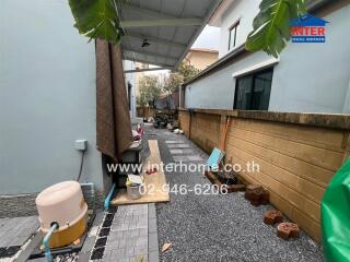 Covered pathway and backyard area with paving and garden equipment