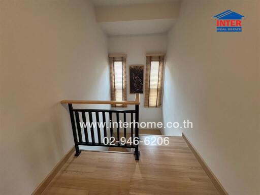 Stairwell with wooden handrail and window shades