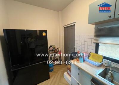 Modern kitchen with black refrigerator and sink area