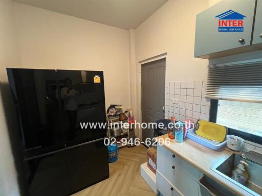 Modern kitchen with black refrigerator and sink area