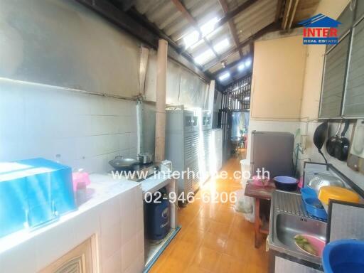 Indoor kitchen area featuring sink, stove, and various appliances