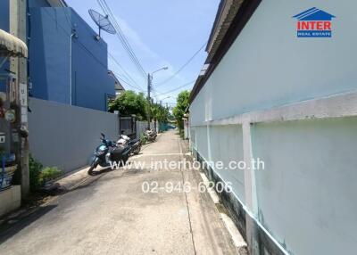 Narrow residential street with parked motorcycles and adjacent houses