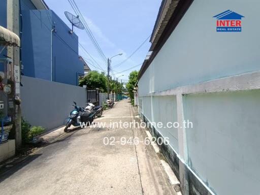 Narrow residential street with parked motorcycles and adjacent houses