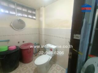 Bathroom with toilet, mirror, and bins