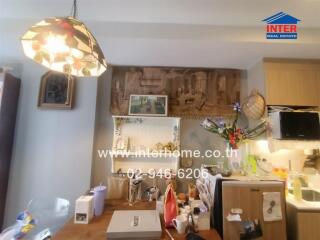 Kitchen with hanging light, wooden cabinetry, and various decorations