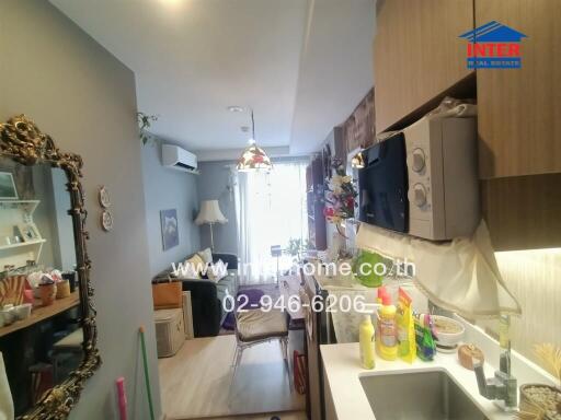 Living area with kitchenette, wall-mounted TV, and decorative elements