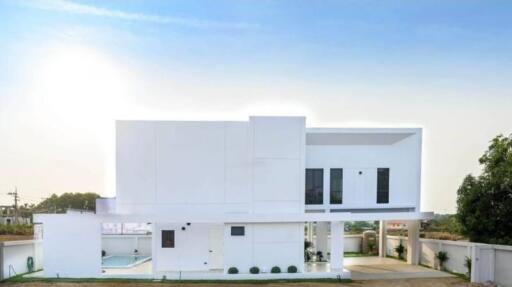 Modern white two-story house with large windows and surrounding yard