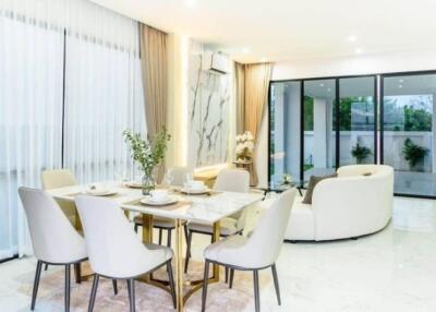 Modern living and dining area with large windows and elegant furnishings