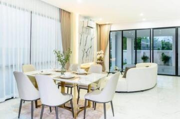 Modern living and dining area with large windows and elegant furnishings