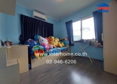 A cozy bedroom with colorful stuffed toys on the bed and dark curtains over the windows
