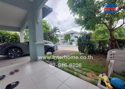 View of a house exterior showing a carport, front yard, and neighboring houses