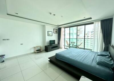 Spacious modern bedroom with glass doors to balcony
