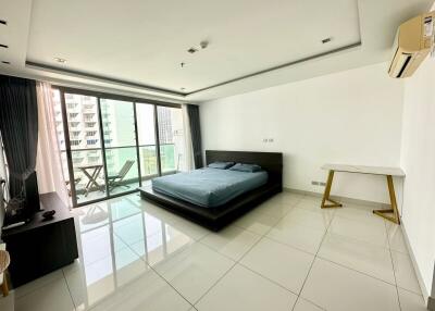 Spacious bedroom with glass doors opening to a balcony