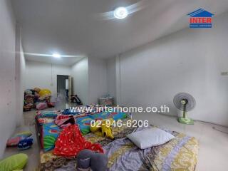 A bedroom with mattresses on the floor and various household items