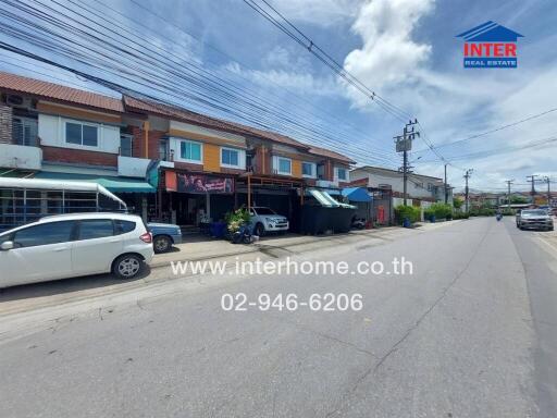 Street view of residential buildings with cars parked in front