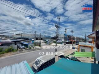 View of street from property with commercial buildings and blue sky