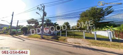 front view of a property with a fence and surrounding greenery