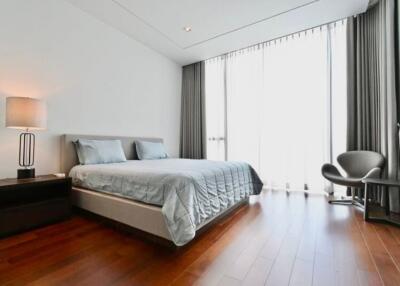 Modern bedroom with large window and hardwood flooring