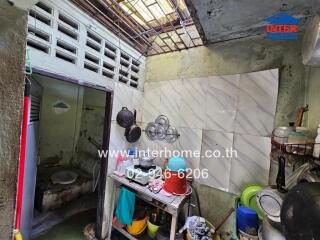 Small kitchen with various utensils and storage shelves