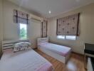 Bedroom with two single beds, air conditioning, wooden floor, and window blinds